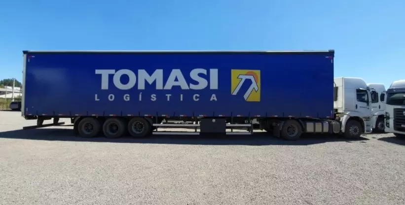 A foto mostra a carreta da empresa Tomasi Logística